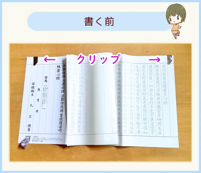 あかしや悠々写経セットの手本と専用の写経用紙をクリップでとめている